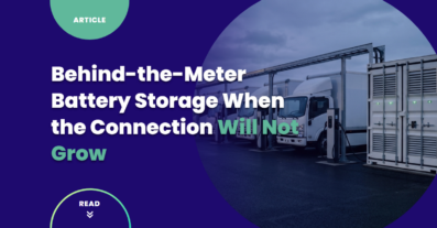 A containerized battery storage unit beside a row of electric delivery trucks plugged into charging pedestals at a fleet depot at dusk, illustrating behind-the-meter battery storage on a fixed grid connection.